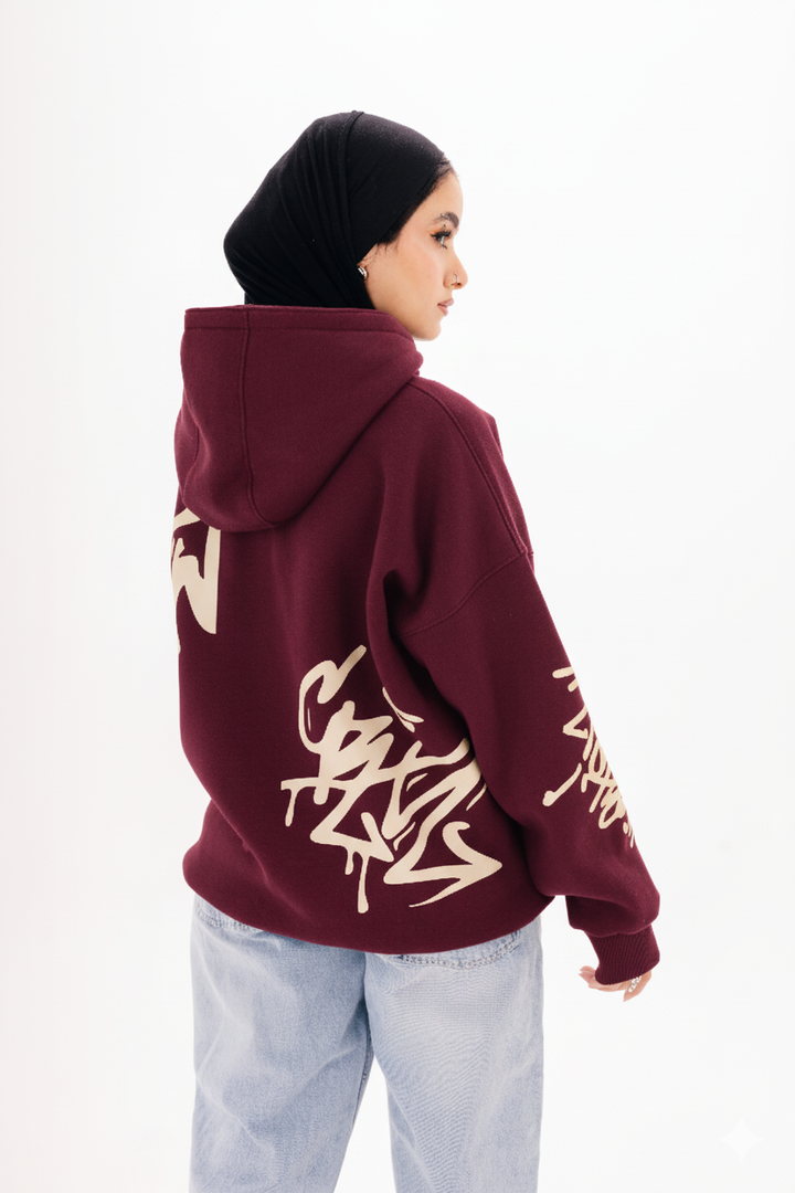 Unisex burgundy graffiti hoodie with white DTF print by BLANCKA — on model
