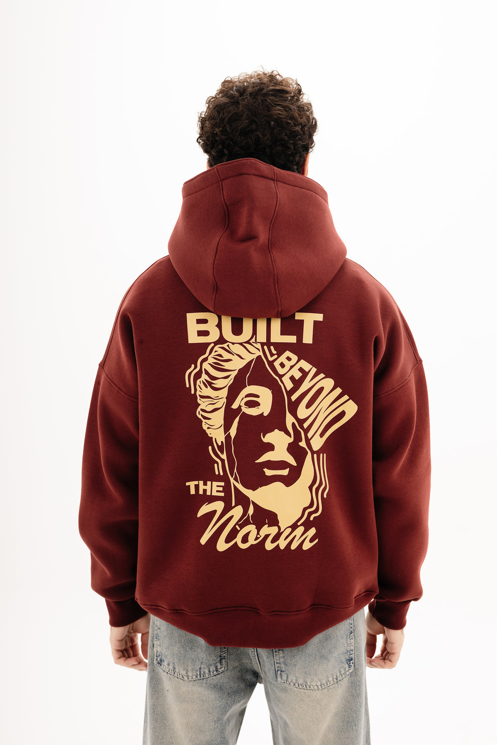 Unisex burgundy hoodie with DTF front and back print by BLANCKA — on model
Back view burgundy hoodie with built beyond graphic — on model
