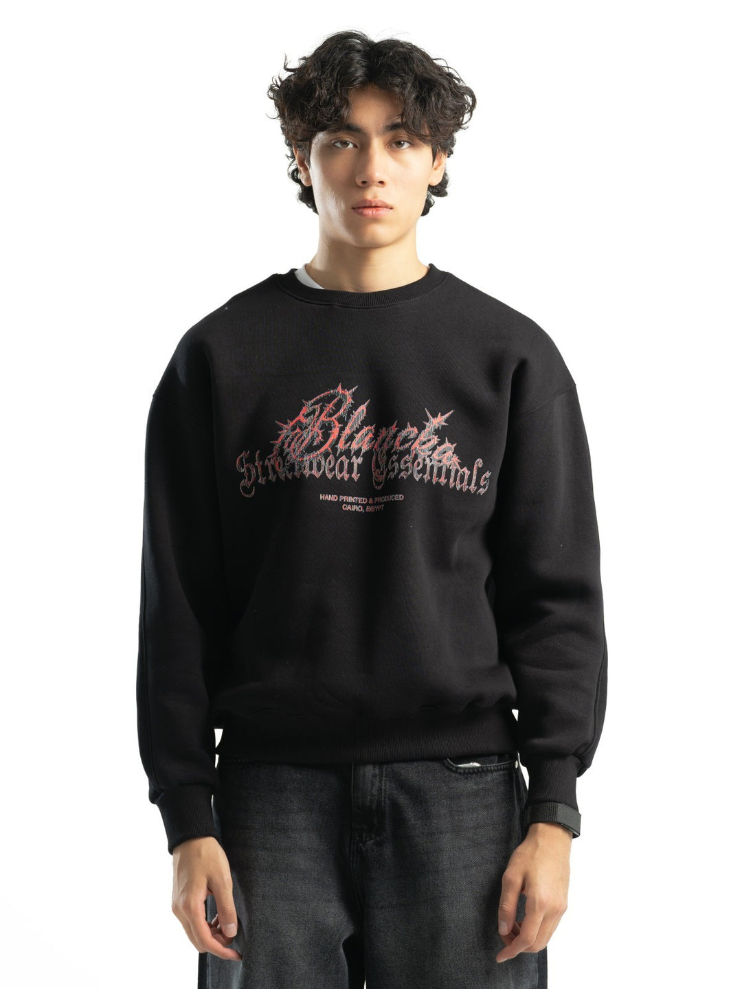Male model wearing BLANCKA Thorns black oversized crewneck with red and grey graphic