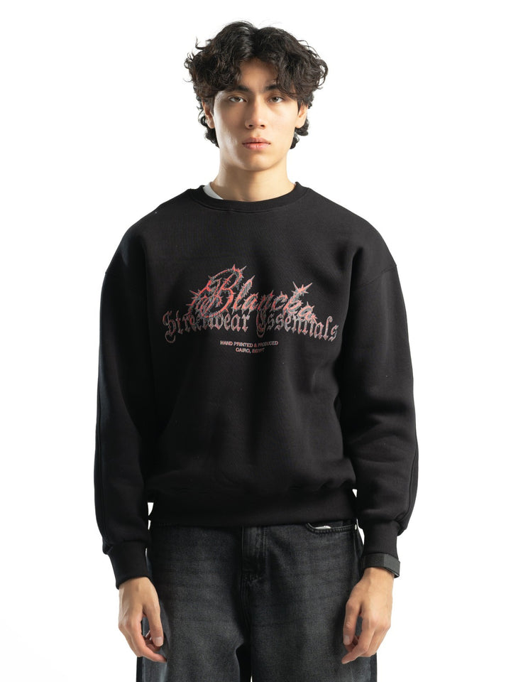 Male model wearing BLANCKA Thorns black oversized crewneck with red and grey graphic