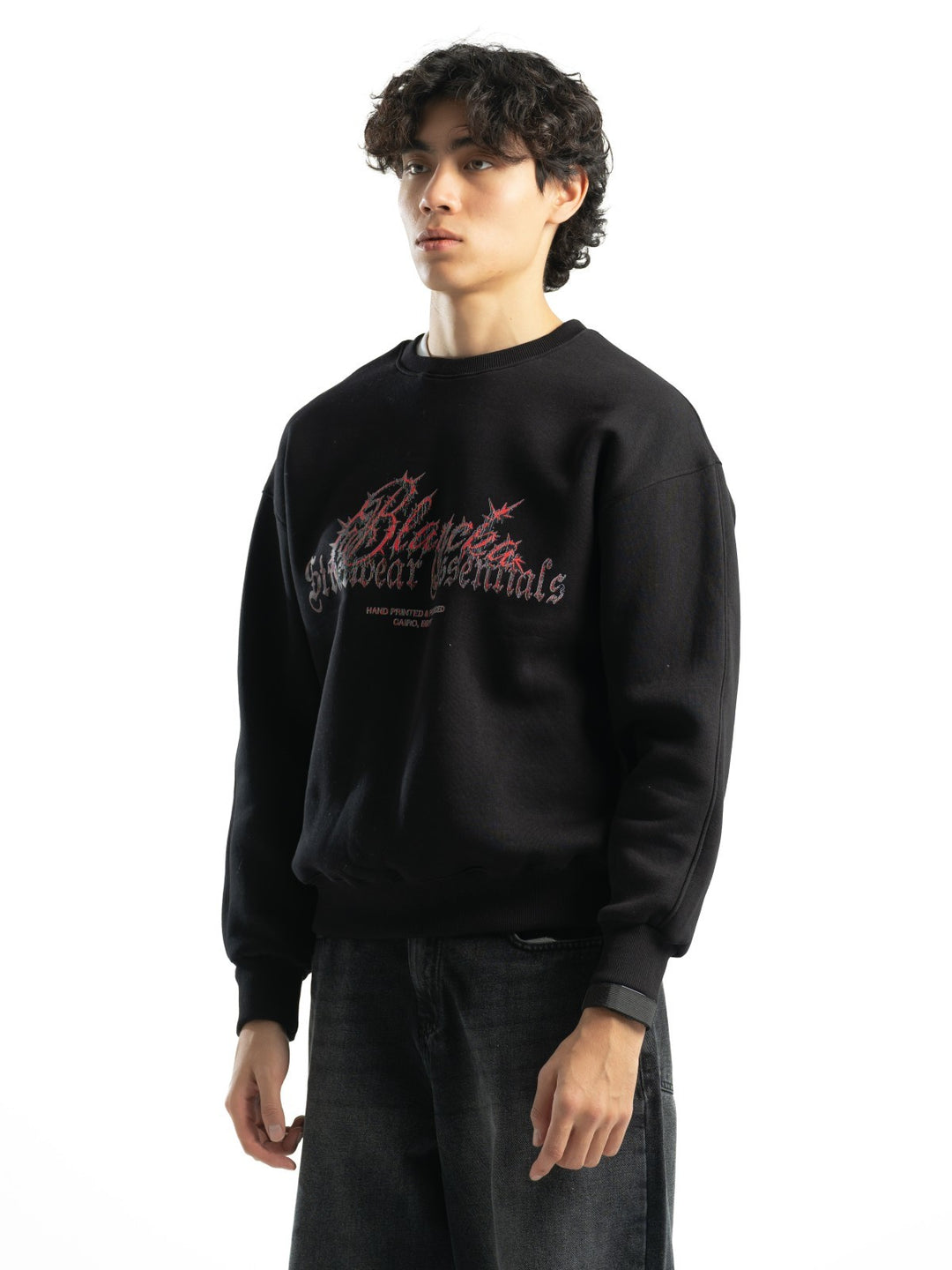 Male model wearing BLANCKA Thorns black oversized crewneck with red and grey graphic