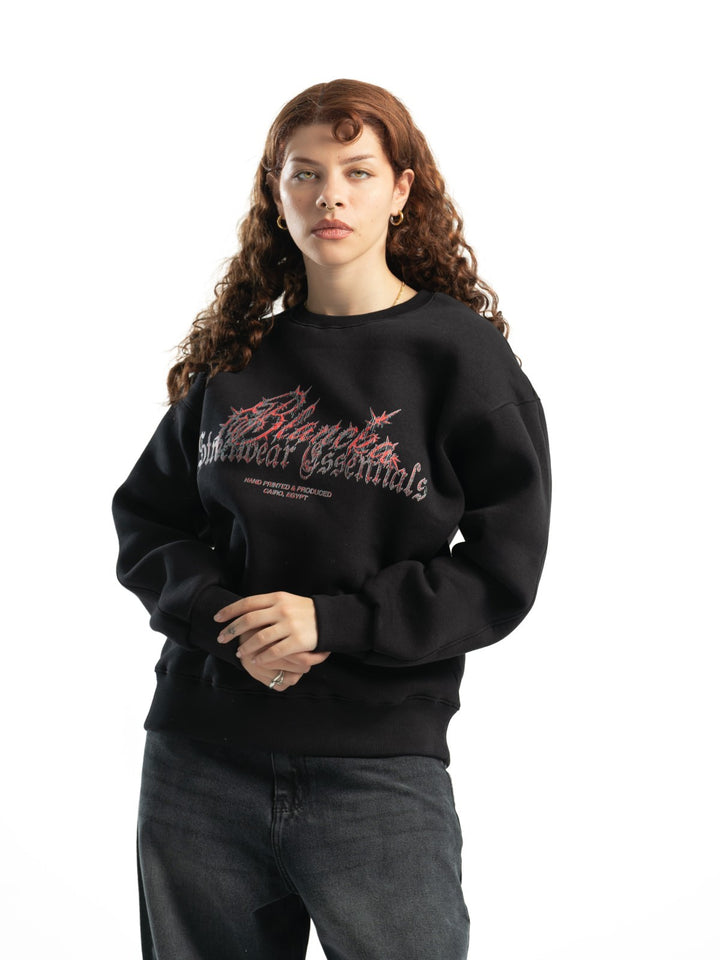 Female model wearing BLANCKA Thorns black oversized crewneck with thorn-inspired graphic