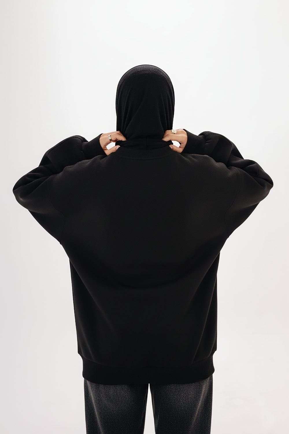 Model wearing Blancka oversized black basic crewneck sweatshirt — minimalist winter collection. 