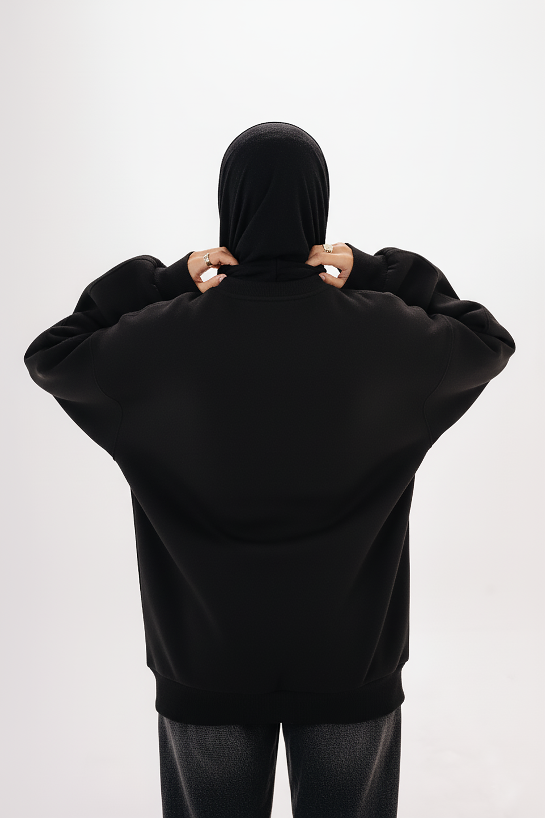 Model wearing Blancka oversized black basic crewneck sweatshirt — minimalist winter collection. 