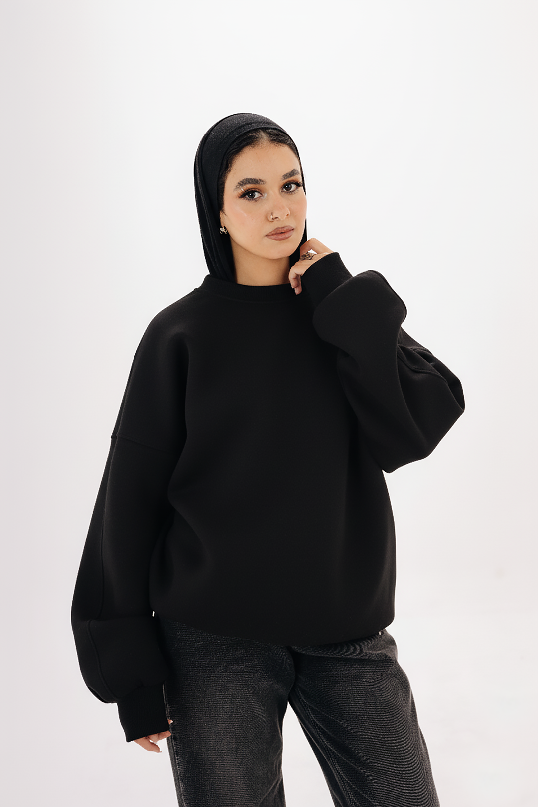 Model wearing Blancka oversized black basic crewneck sweatshirt — minimalist winter collection. 