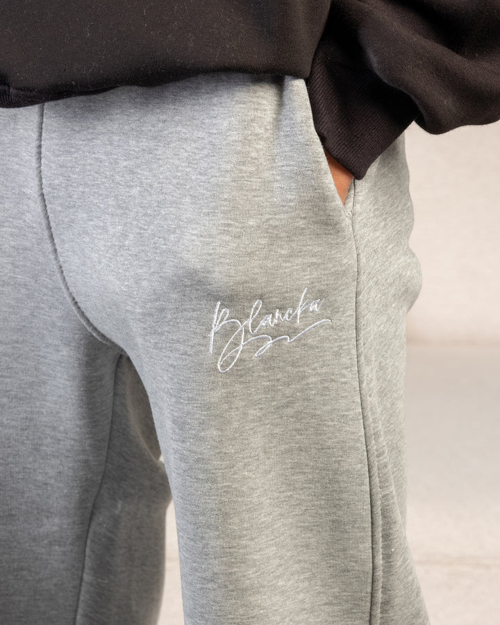 “Gray fleece sweatpants fabric texture – BLANCKA embroidery close-up”