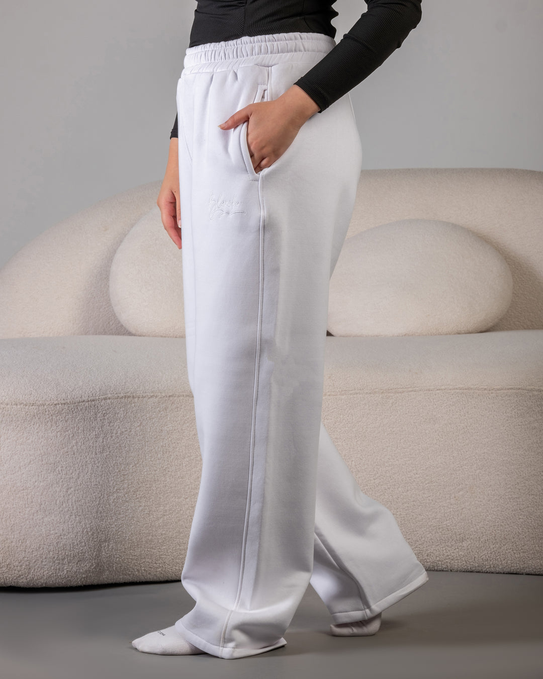 “White fleece sweatpants fabric texture – BLANCKA embroidery close-up”