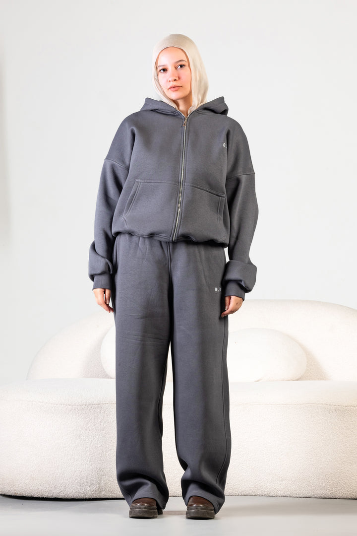Unisex oversized zip hoodie set in charcoal grey with wide-leg sweatpants – BLANCKA Winter 2025.

